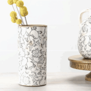 Elegant white ceramic vase with intricate floral patterns and yellow billy balls.